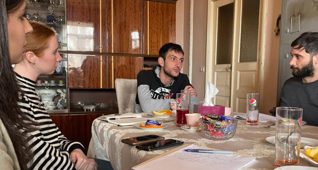 Annie McGovern ’22 (second from left) and Diego Olivieri ’24 (far right) interview a former prisoner of war.